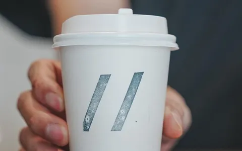 Hand holding a Parallel takeaway cup